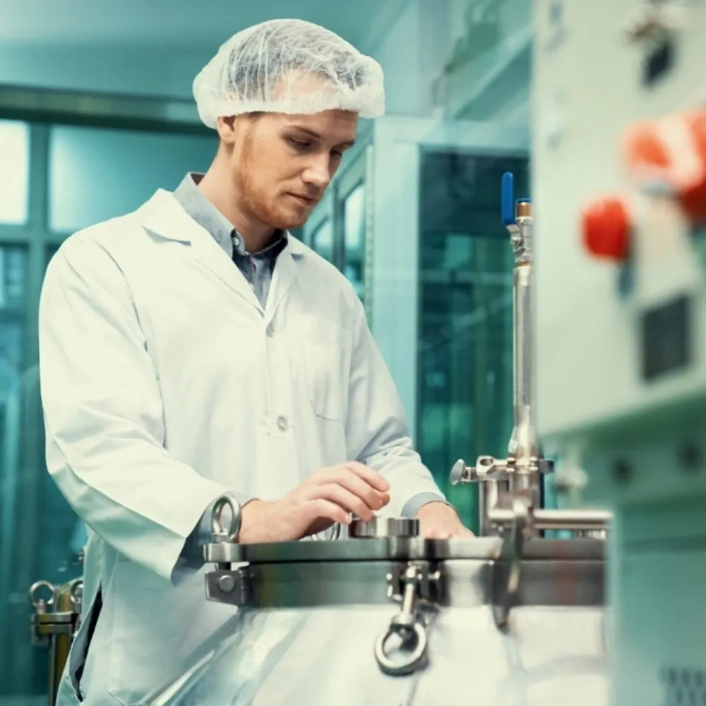 Technicien en laboratoire travaillant sur l'extraction et la production d'huile de CBD dans un environnement contrÎlé.