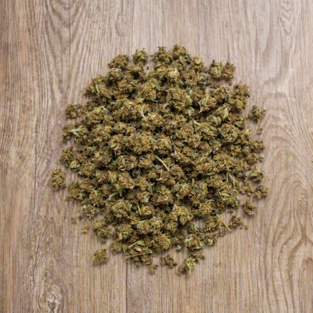 Fleurs CBD 100g Strawberry présentées sur fond bois. Petits bourgeons séchés issus de chanvre légal et contrôlé.