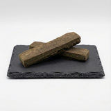 BBM Hash GR33NZ présenté sur ardoise : résine CBD bio artisanale, compacte et pure, conçue à partir de pollen de chanvre pressé sans solvants.