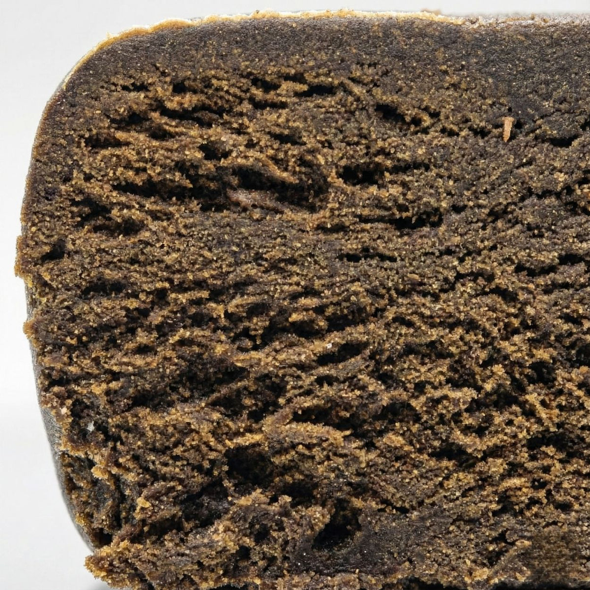 Photo macro du hashish CBD King Hassan GR33NZ, 25 % de CBD. Résine bio artisanale inspirée du Maroc, texture riche et arômes poivrés et naturels.
