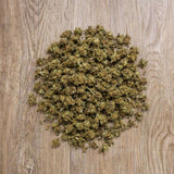 Fleurs CBD 100g Strawberry présentées sur fond bois. Petits bourgeons séchés issus de chanvre légal et contrôlé.