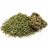 Trim CBD Harlequin avec sa fleur CBD sur fond blanc, montrant un tas de trim vert finement broyé accompagné d’une tête de fleur riche en trichomes.